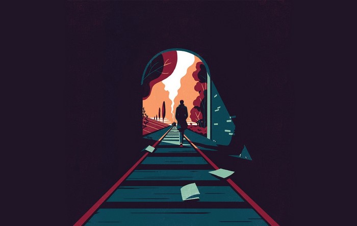 Man walking through a tunnel on train tracks