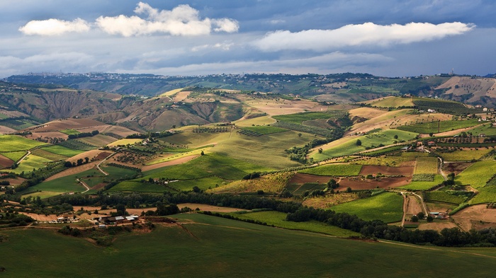 Rolling hills with agricultural fields and a distant town