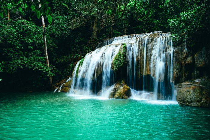 Waterfall cascading into a turquoise pool in a lush forest