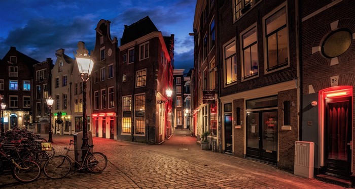Amsterdam street at night with red lights and bicycles