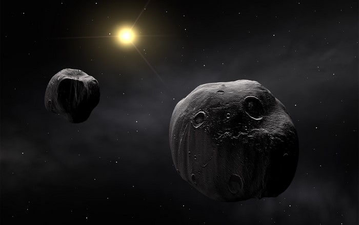 Two asteroids in space with a bright star
