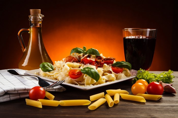 Pasta with tomatoes and basil, olive oil, and a drink