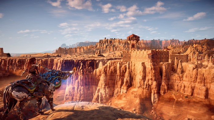 Aloy on a mechanical mount overlooking a canyon in Horizon Zero Dawn