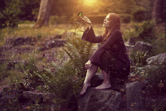 Elf woman with butterfly in a forest
