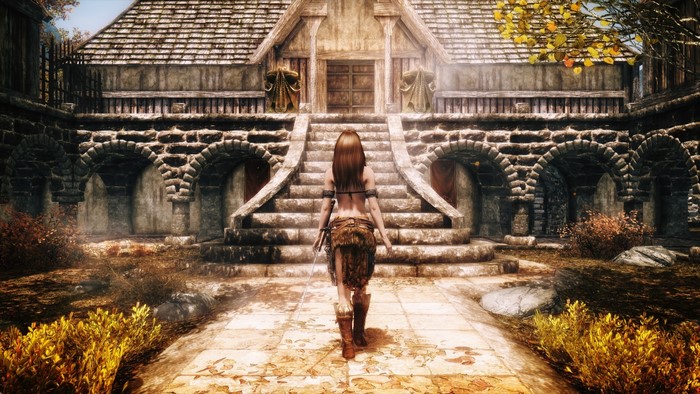 Woman in fur skirt walking towards Skyrim building