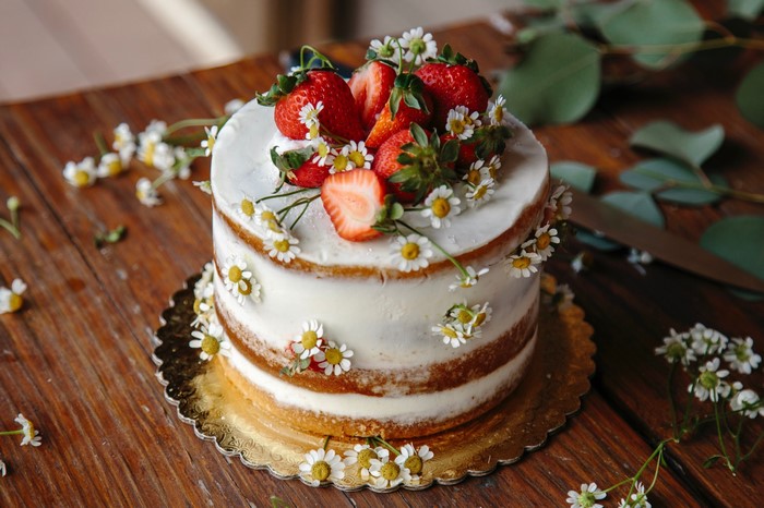 Naked cake decorated with strawberries and daisies