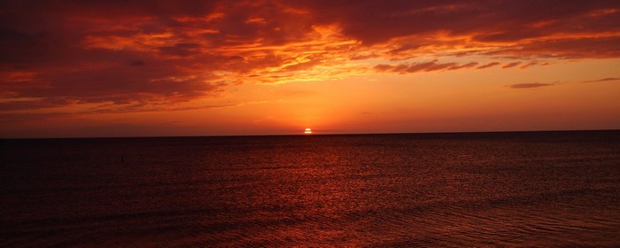 Sunset over the ocean with dramatic clouds