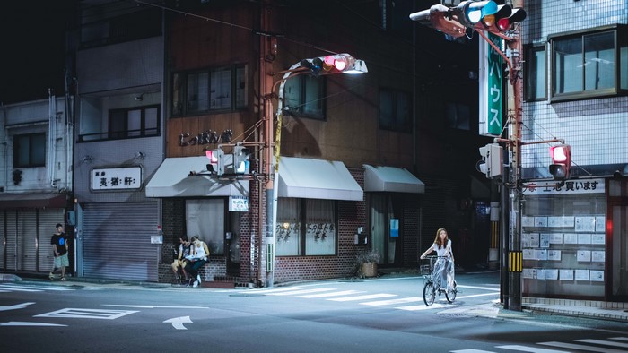 Night street scene in Japan with traffic lights and people