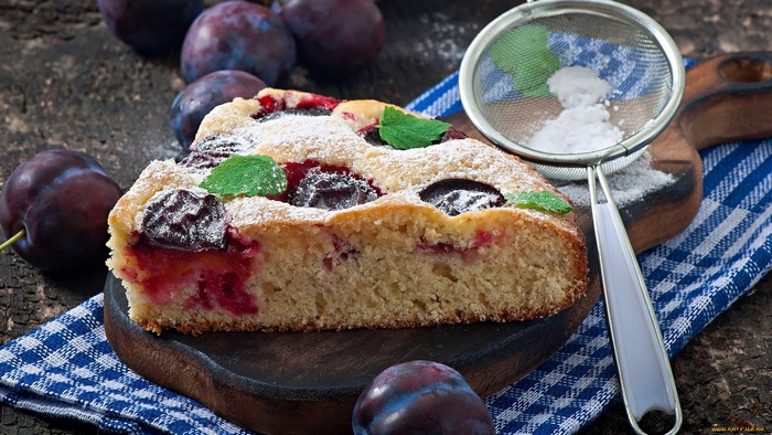 Plum cake with powdered sugar and mint leaves