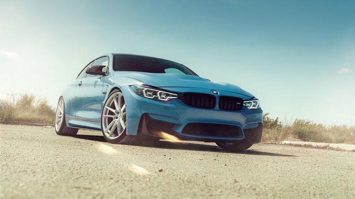 Blue BMW M4 on a dirt road