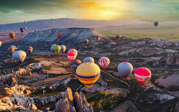 Hot air balloons over Cappadocia mountains at sunrise