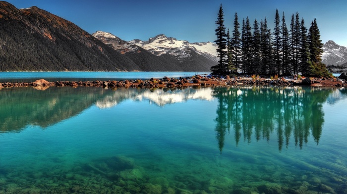 Turquoise lake with mountains and pine trees