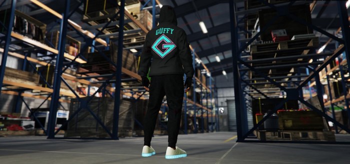 Man in hoodie with 'GUFFY' logo in a warehouse