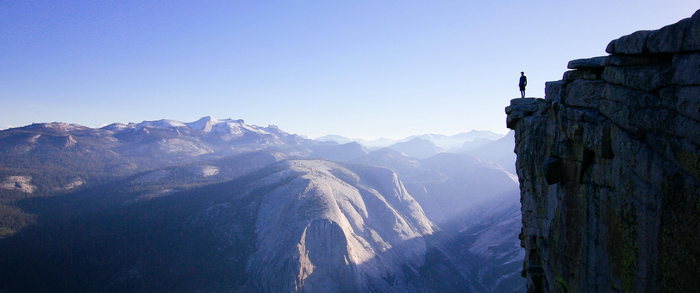 Man standing on a cliff edge in Yosemite National Park