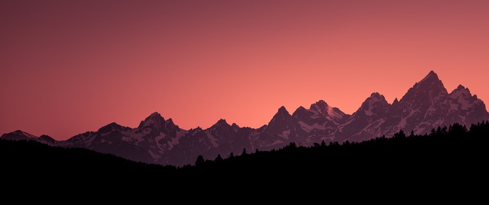 Silhouette of snow-capped mountains at sunset