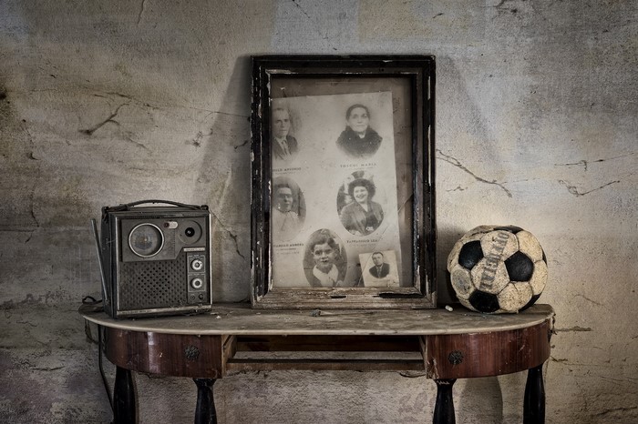 Old radio, framed family photos, and soccer ball on a table