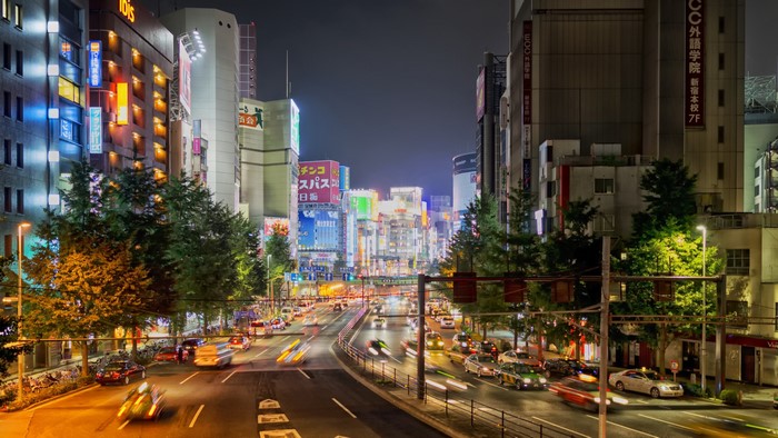 Nighttime city street with traffic and neon lights in Japan