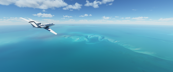 Cessna Citation CJ4 flying over turquoise ocean
