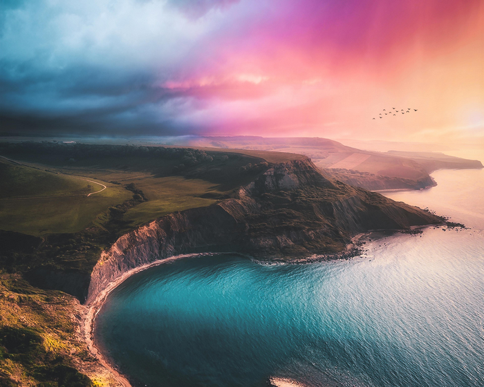 Aerial view of Dorset coast with colorful sky and birds