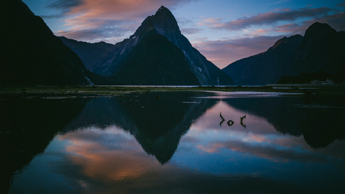 Milford Sound New Zealand at sunset with mountain reflection