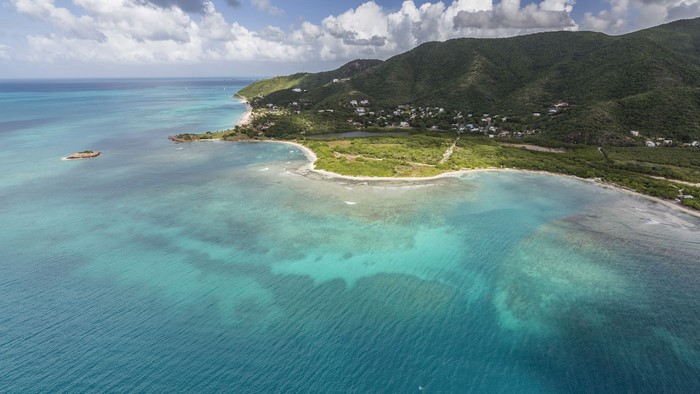 Aerial view of a Caribbean island with turquoise waters and green hills