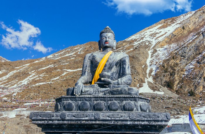 Buddha statue in snowy mountain landscape