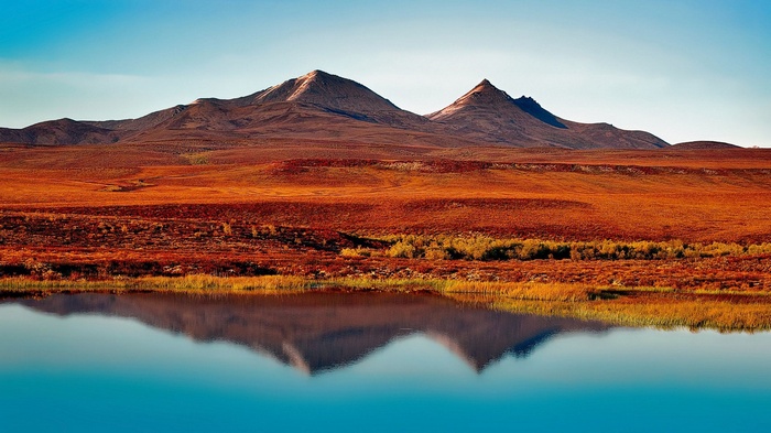 Mountains reflected in a lake with autumn tundra