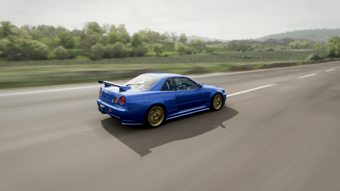 Blue Nissan Skyline R34 driving on a road in Forza Horizon 4