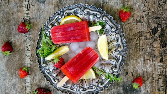 Strawberry popsicles with lemon and mint on a decorative plate