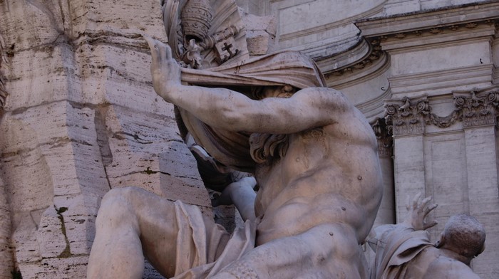 Statue of a man covering his face in Rome, Italy