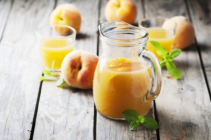 Peach juice in a pitcher with peaches and mint