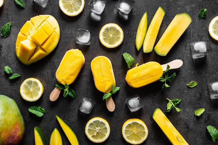 Yellow mango popsicles with lemon slices and mint