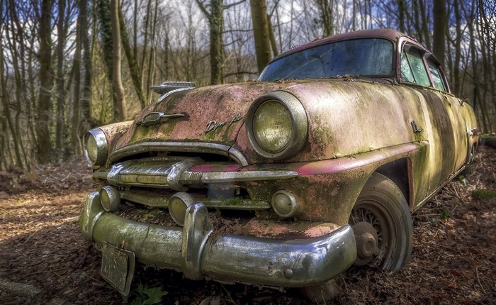 Abandoned vintage car in a forest