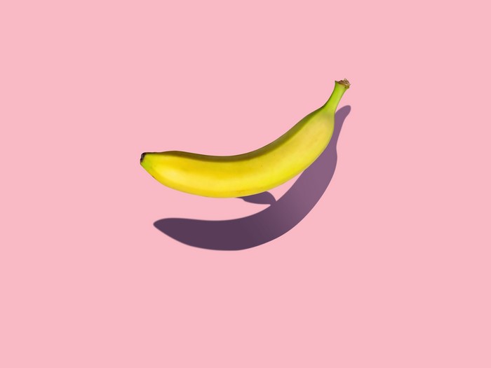 Banana with shadow on pink background
