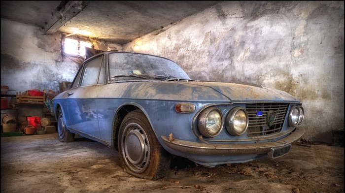 Abandoned blue Lancia Fulvia coupe in a dusty garage