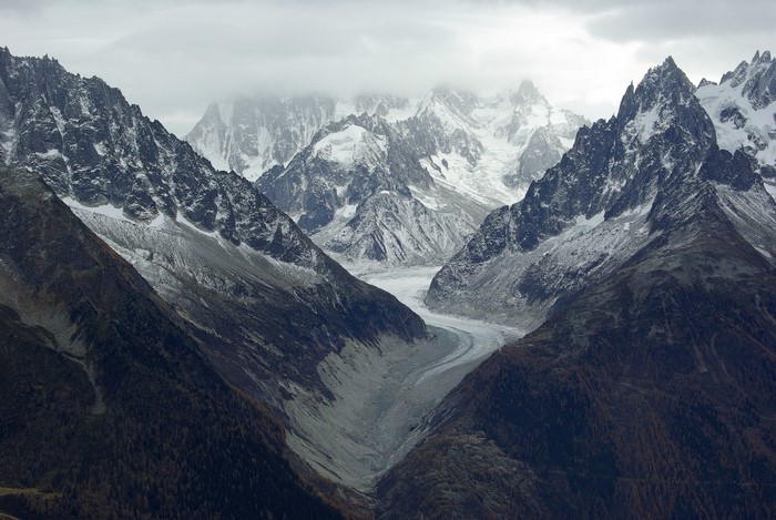 Snow-capped mountains and a glacier under a cloudy sky