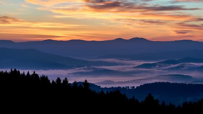 Misty mountains at sunset with colorful clouds