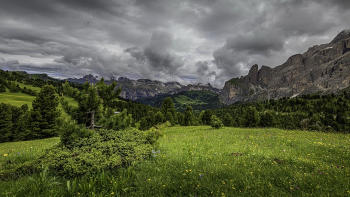 Mountains and green fields under cloudy sky