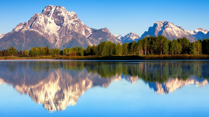 Snow-capped mountains reflected in a calm lake