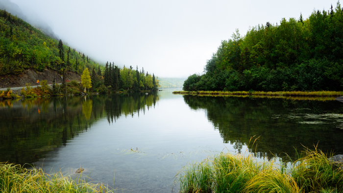 Lake with reflections of trees and mountains in Alaska
