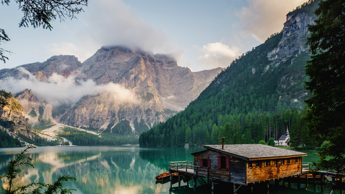 Lake Pragser with wooden boathouse and mountains, Italy