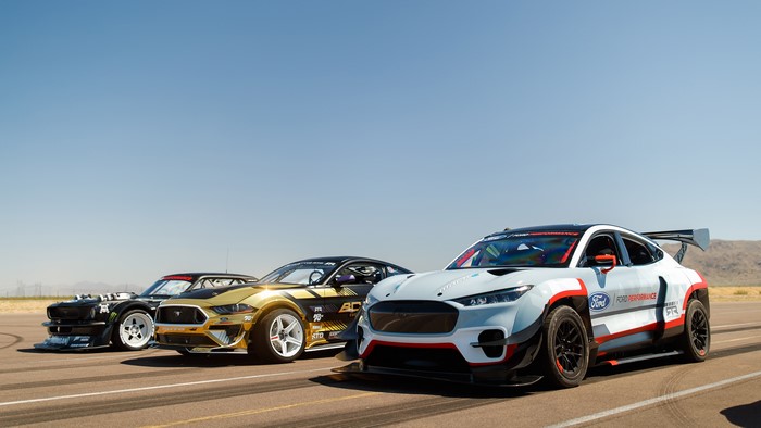 Three Ford Mustang race cars on a track