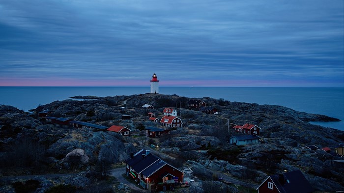 Lighthouse village on rocky coast at dusk