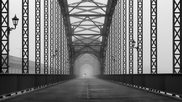 Cyclist on a foggy bridge in Germany
