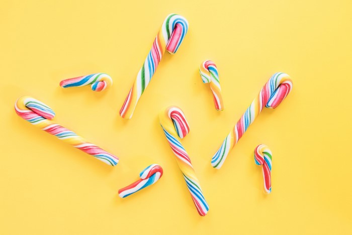 Colorful candy canes on a yellow background