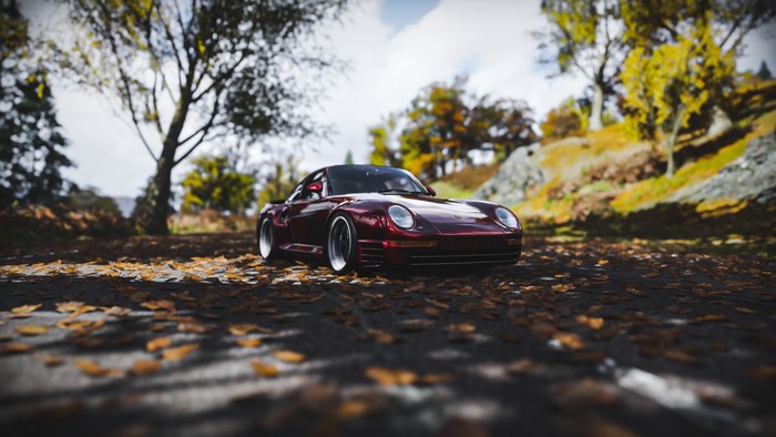 Red Porsche 959 on a leaf-covered road in Forza Horizon 4