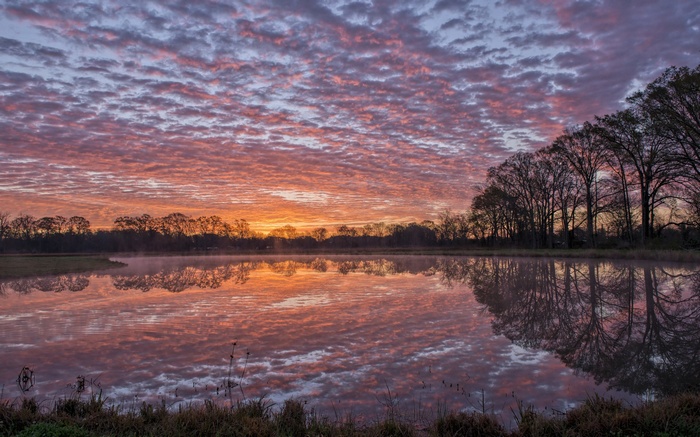 Sunrise over a misty lake with colorful clouds
