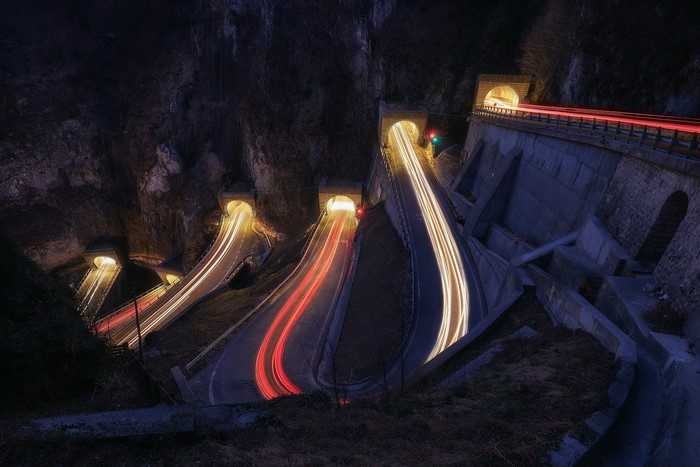 Road with light trails through tunnels at night