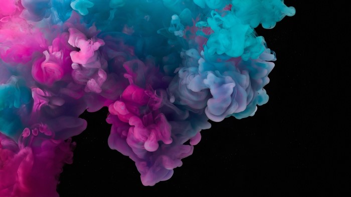 Pink and blue ink swirling in black liquid