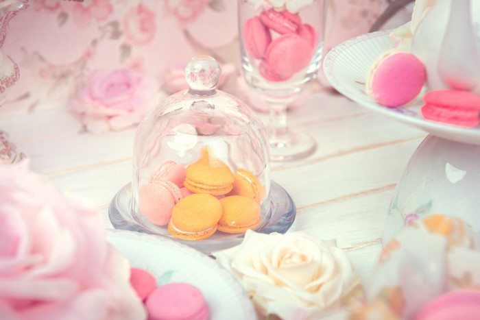 Pink and orange macarons on a table with roses